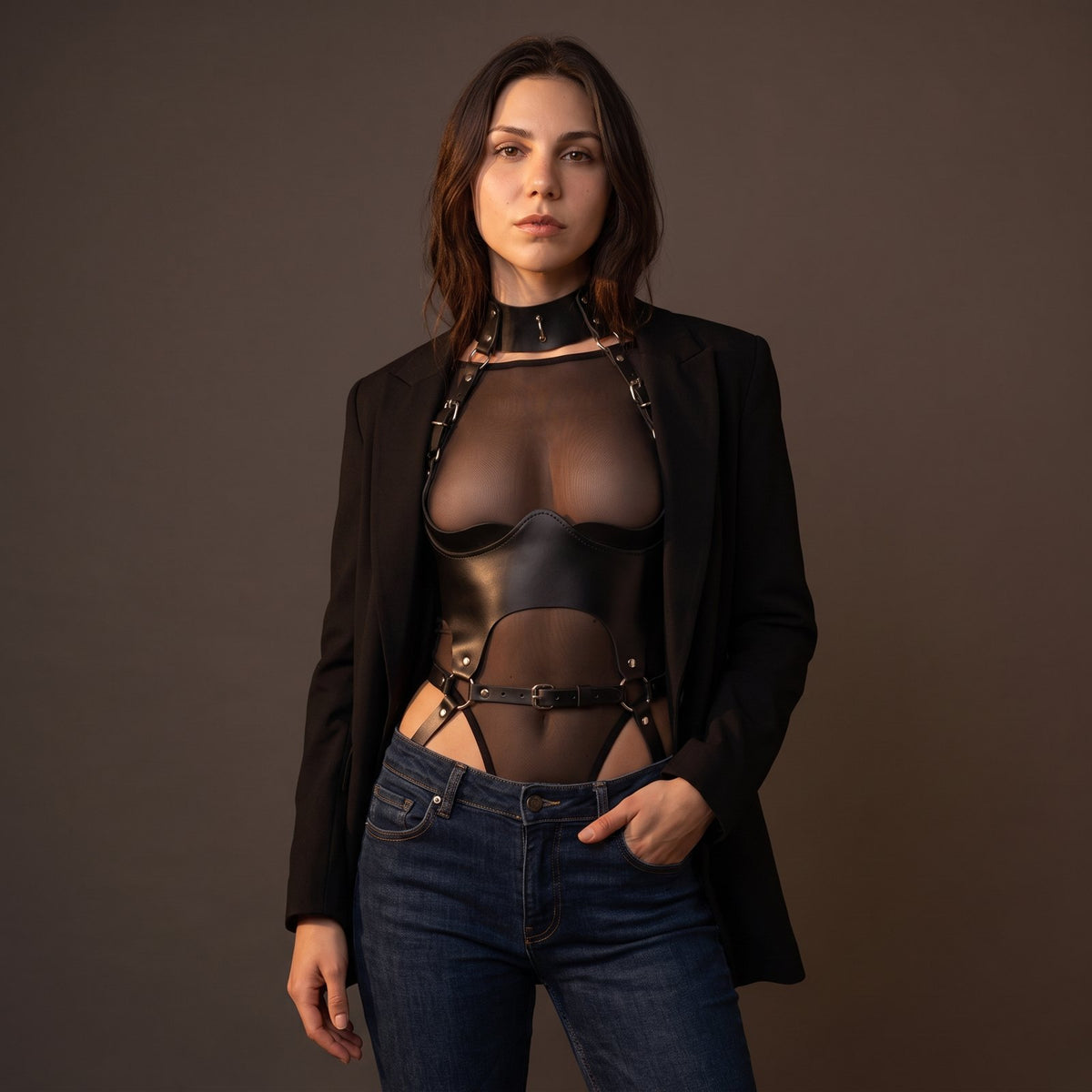 Tara's Body Harness layered over a sheer top under a black blazer